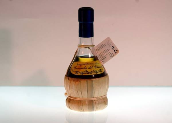 Small flask in chianti wine glass containing lavender shampoo