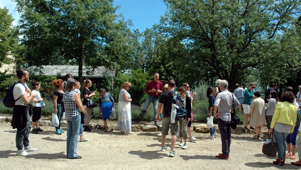 Un gruppo di turisti mentre esplora il giardino botanico di Casalvento detto Viridarium in una giornata di sole primaverile