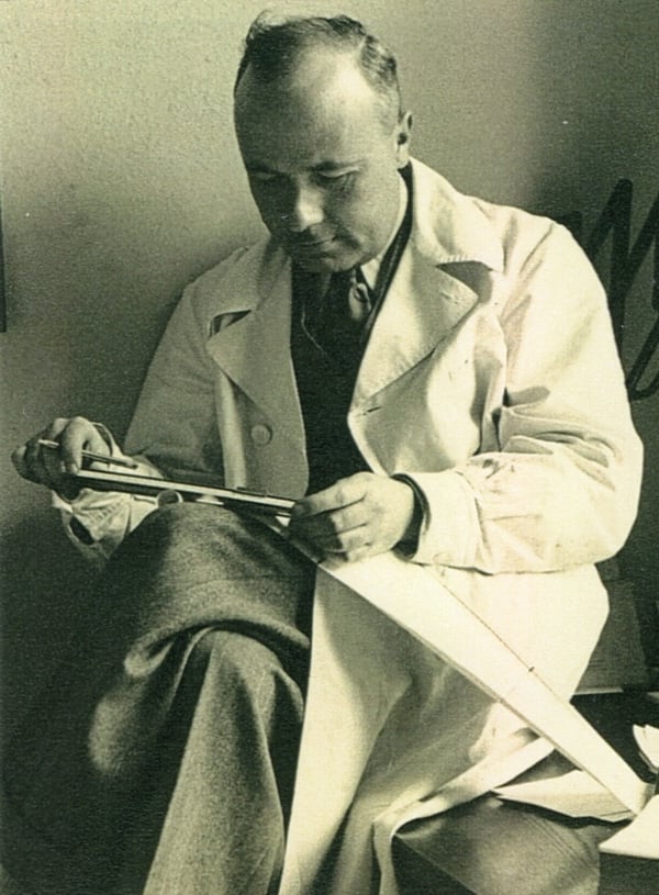 Giovanni Domini in a white coat and seated graduated in Chemistry and Pharmacy as well as in Medicine and Surgery in a black and white photo from the sixties while studying