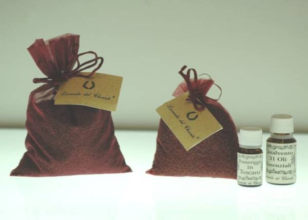 Wine-colored bags with grape seeds and a yellow card with the writing "Lavanda del Chianti" and two bottles of Casalvento essential oils on a bright white background