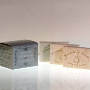 Tris of rectangular solid soaps with silver box and printed writing: "Lavanda del Chianti" and "100% vegetable soap" on a bright white shaded gray surface