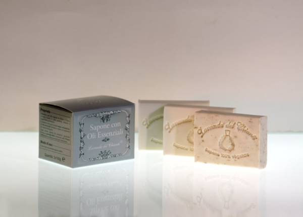 Tris of rectangular solid soaps with silver box and printed writing: "Lavanda del Chianti" and "100% vegetable soap" on a bright white shaded gray surface