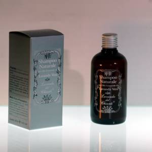 Brown plastic bottle with silver box on a light luminous surface and pink background. Silver framed writing "Lavender Vera natural shampoo" from "Lavanda del Chianti"