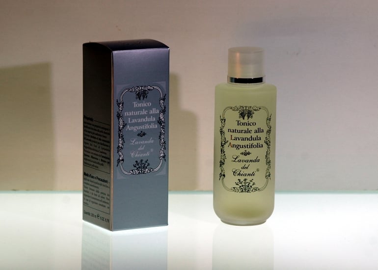 On a light luminous surface and a pink background, a frosted glass bottle and a silver box with the inscription: "Lavender Natural Tonic from Lavender of Chianti"