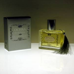 Perfume bottle in transparent glass and metal label with OCHRA written and "Lavanda del Chianti" on the left silver colored perfume box